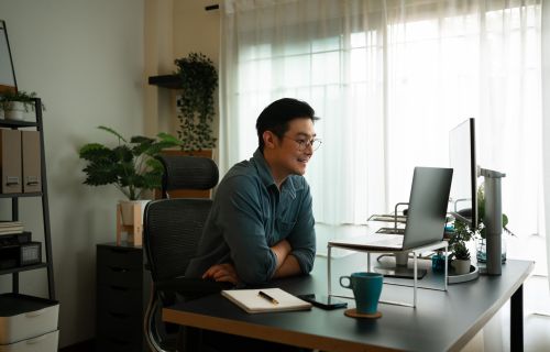 Man explaining business plan to his colleagues on Video conference business meeting via laptop computer at home in the morning. Virtual work concepts.